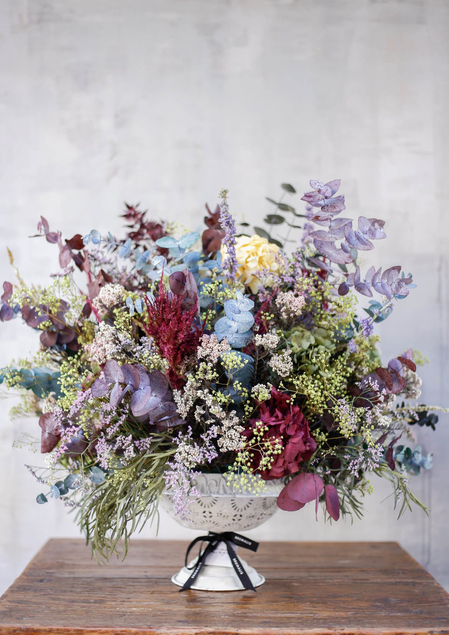 Arreglo de flores preservadas en copa blanca