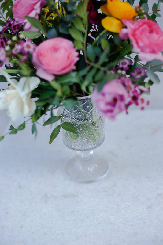 Flores de temporada en copita de cristal labrada