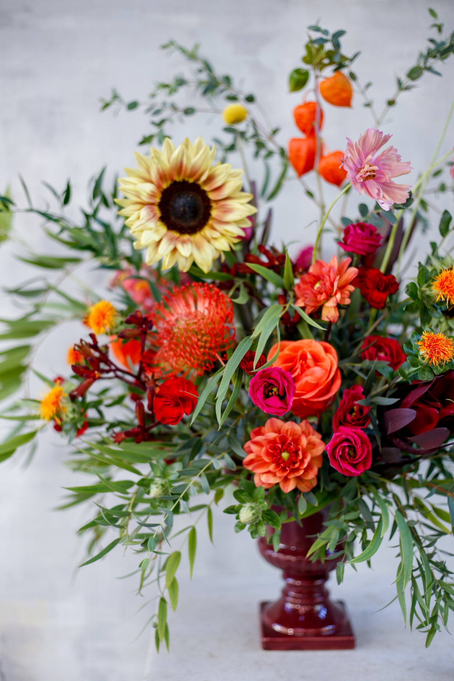 Arreglo de flores otoñal en copa burdeos
