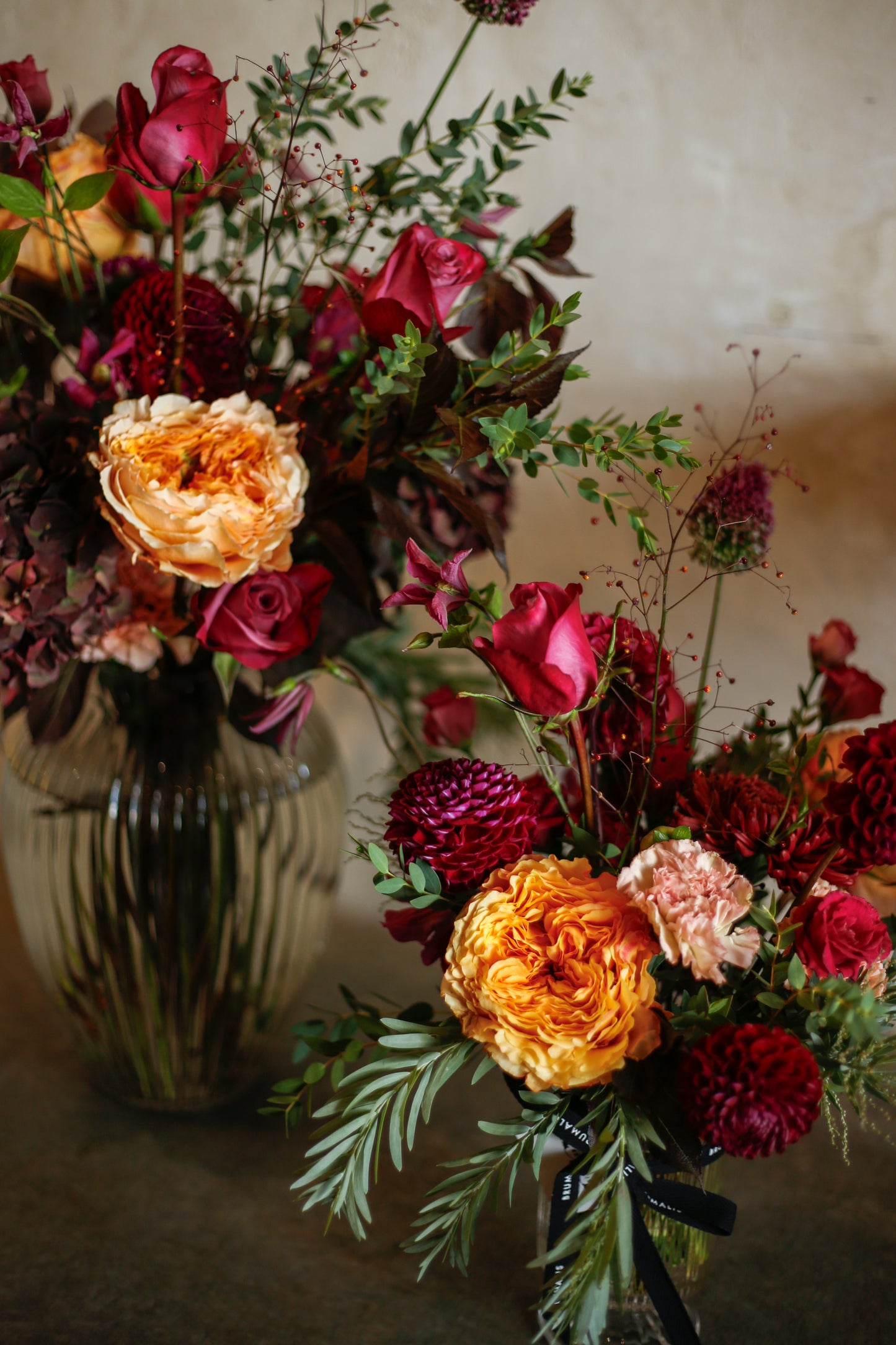 Flores otoñales burdeos en jarrón acanalado