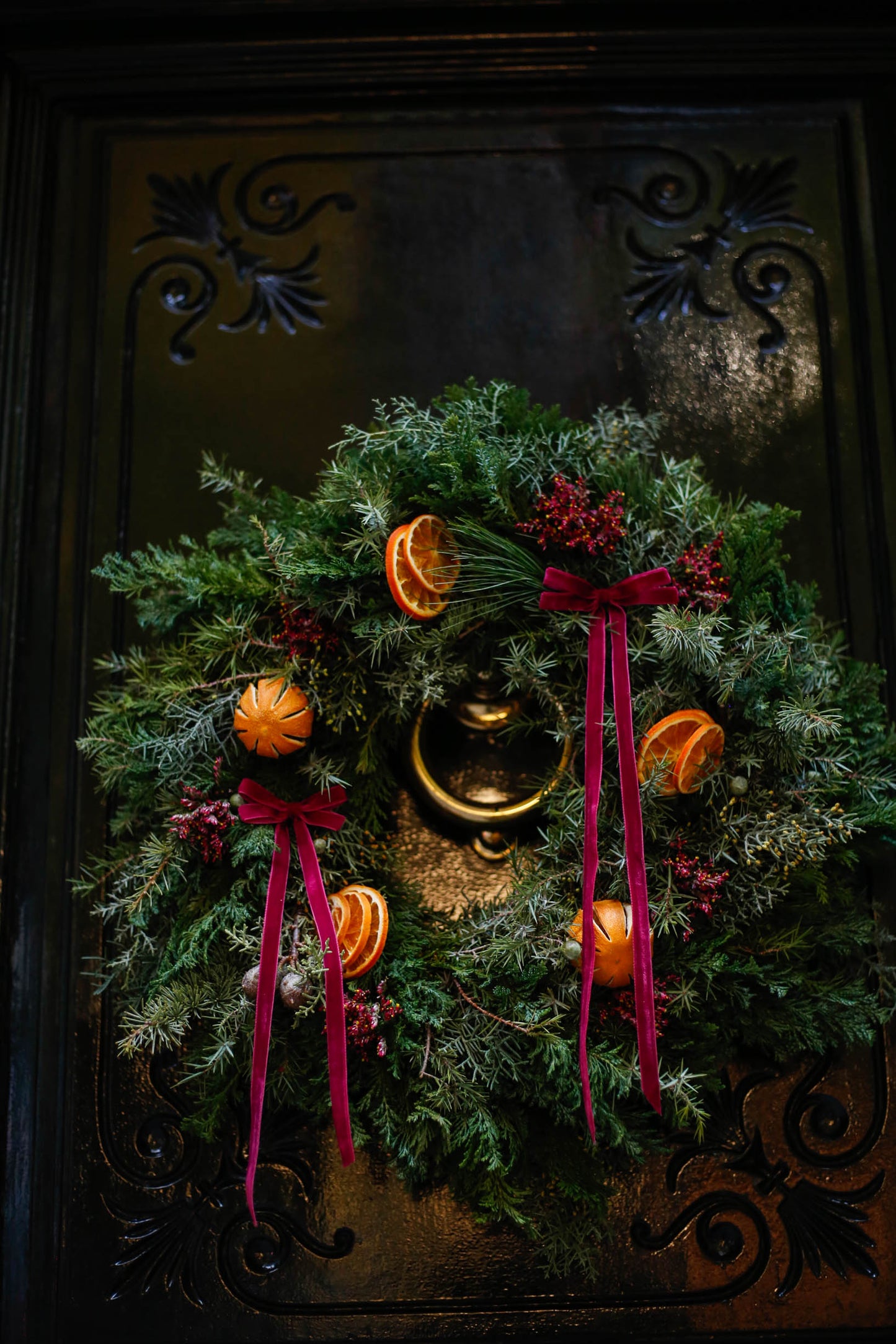 Corona de Navidad con lazos y naranjas