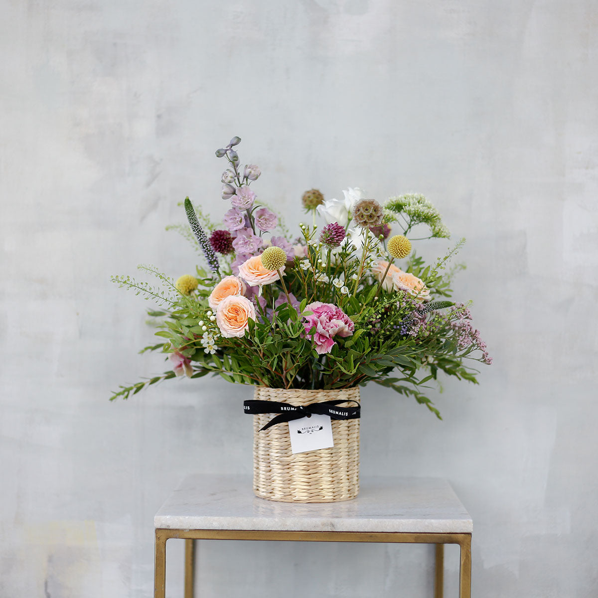 Flores de temporada en cesta beige
