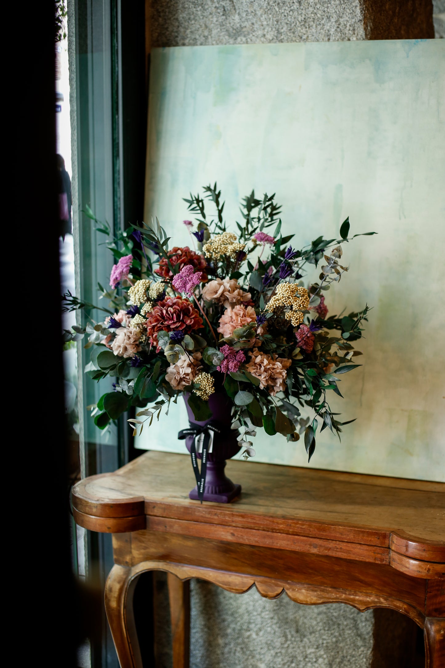 Arreglo de flores preservadas en copa morada