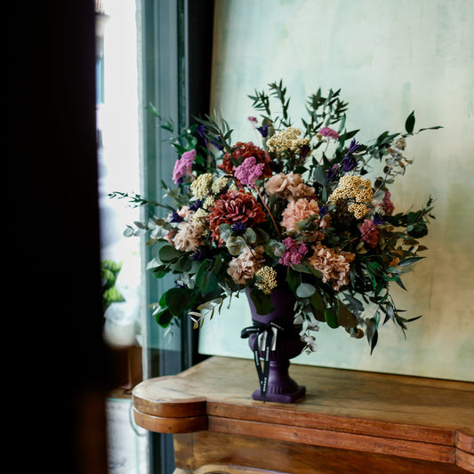 Arreglo de flores preservadas en copa morada