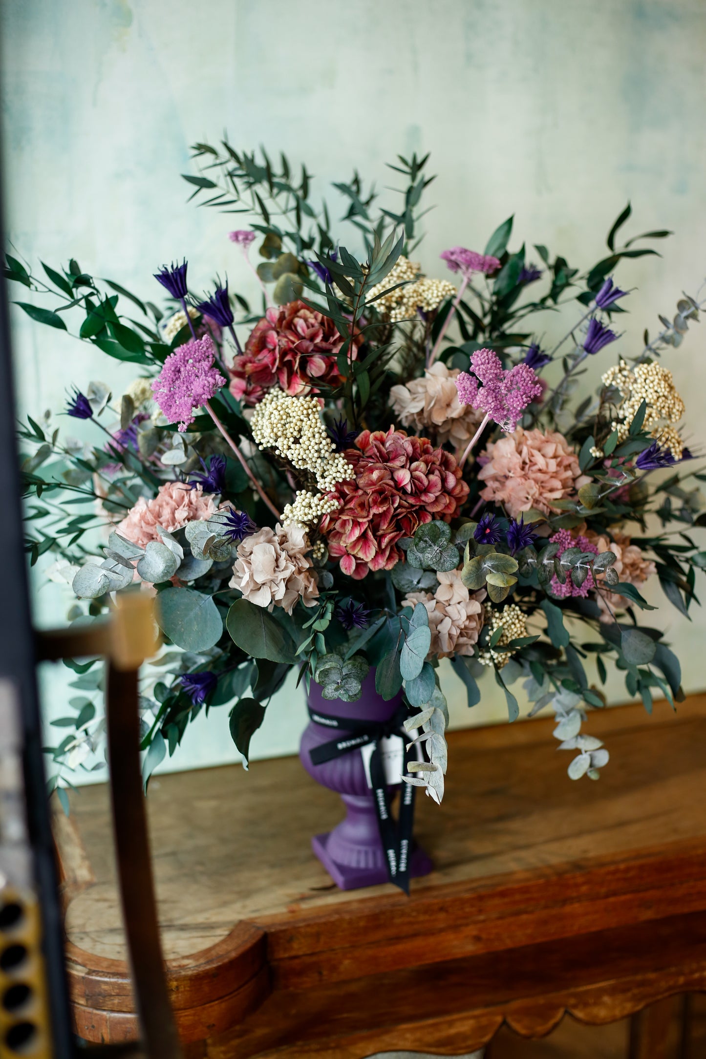 Arreglo de flores preservadas en copa morada