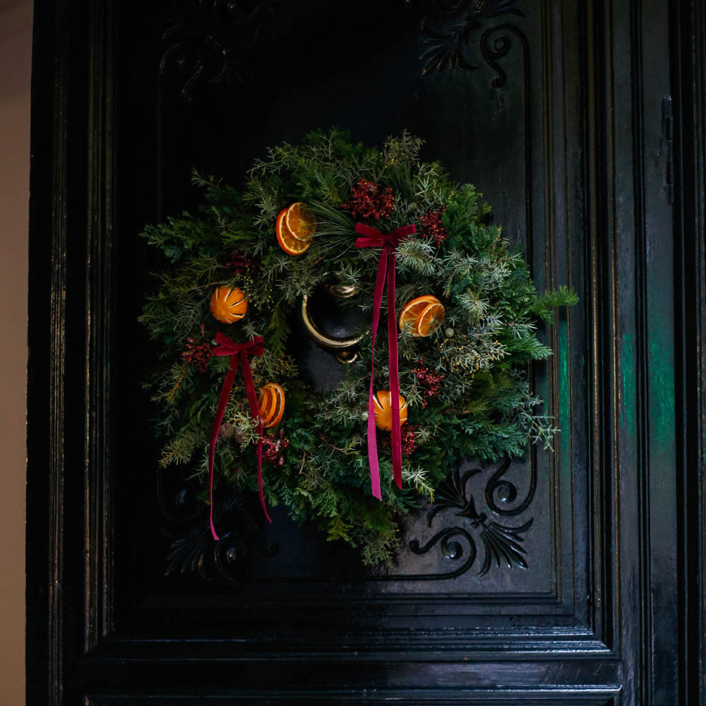 Corona de Navidad con lazos y naranjas