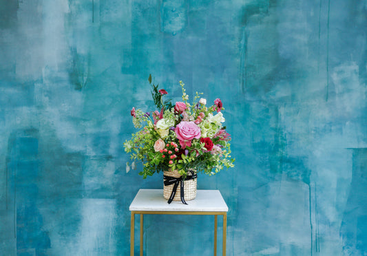 Flores de temporada en cesta beige