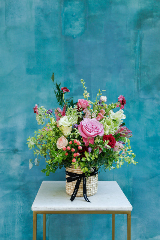 Flores de temporada en cesta beige