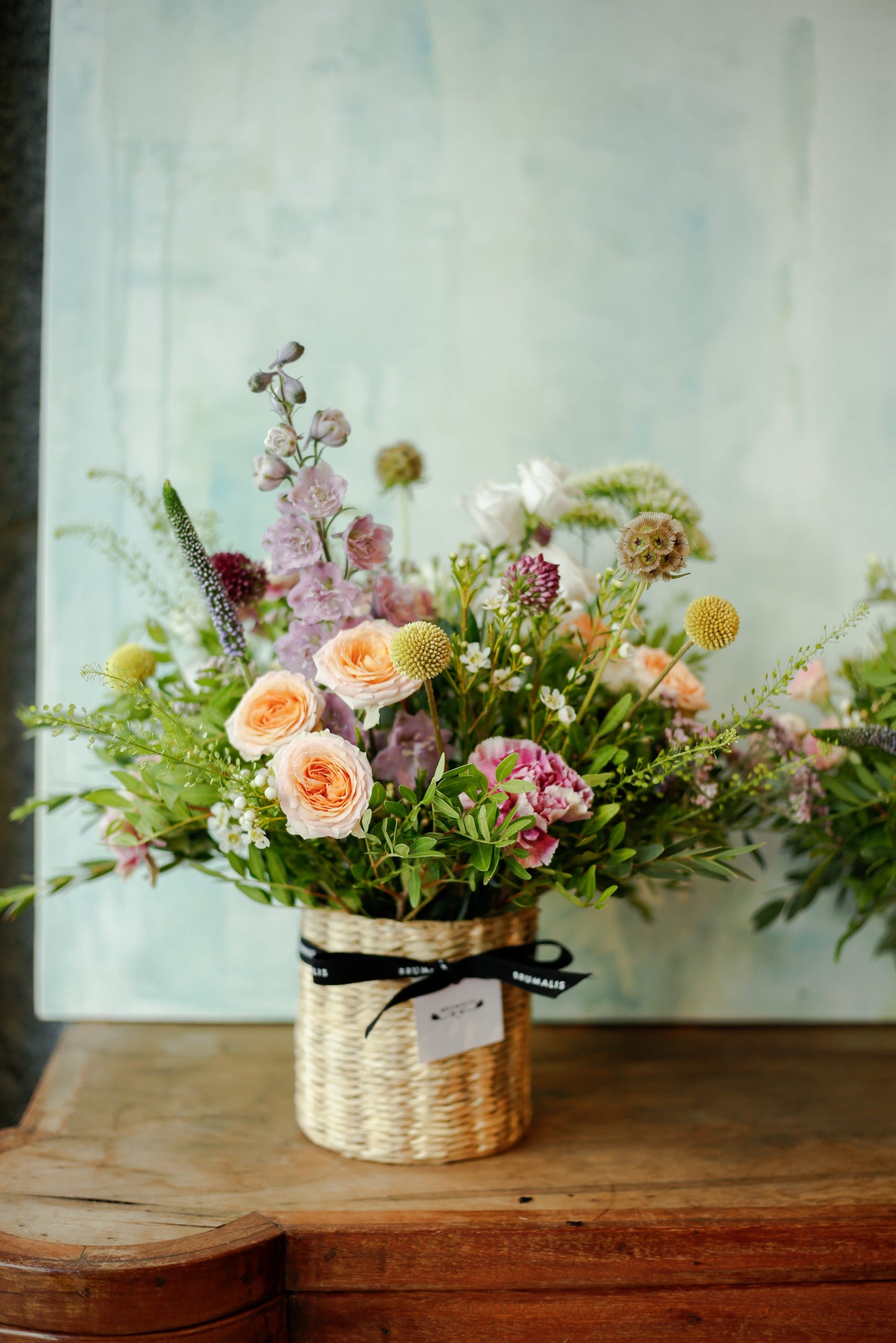 Flores de temporada en cesta beige