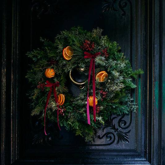 Corona de Navidad con lazos y naranjas