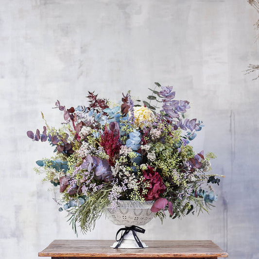 Arreglo de flores preservadas en copa blanca