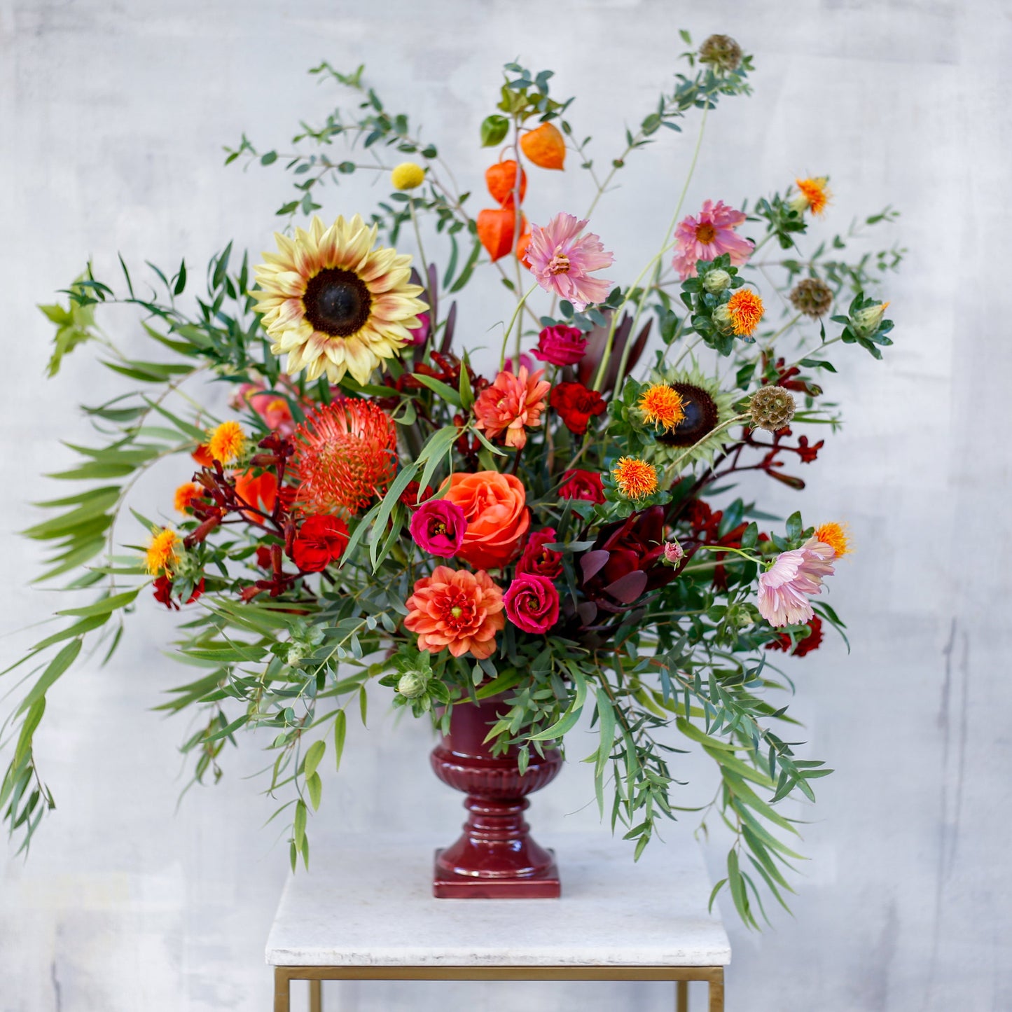Arreglo de flores otoñal en copa burdeos