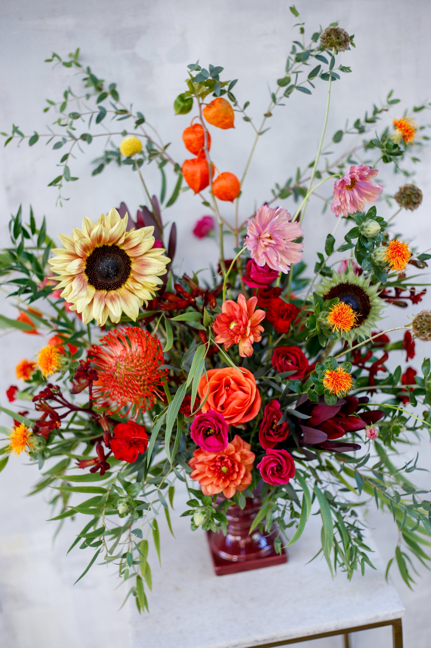Arreglo de flores otoñal en copa burdeos