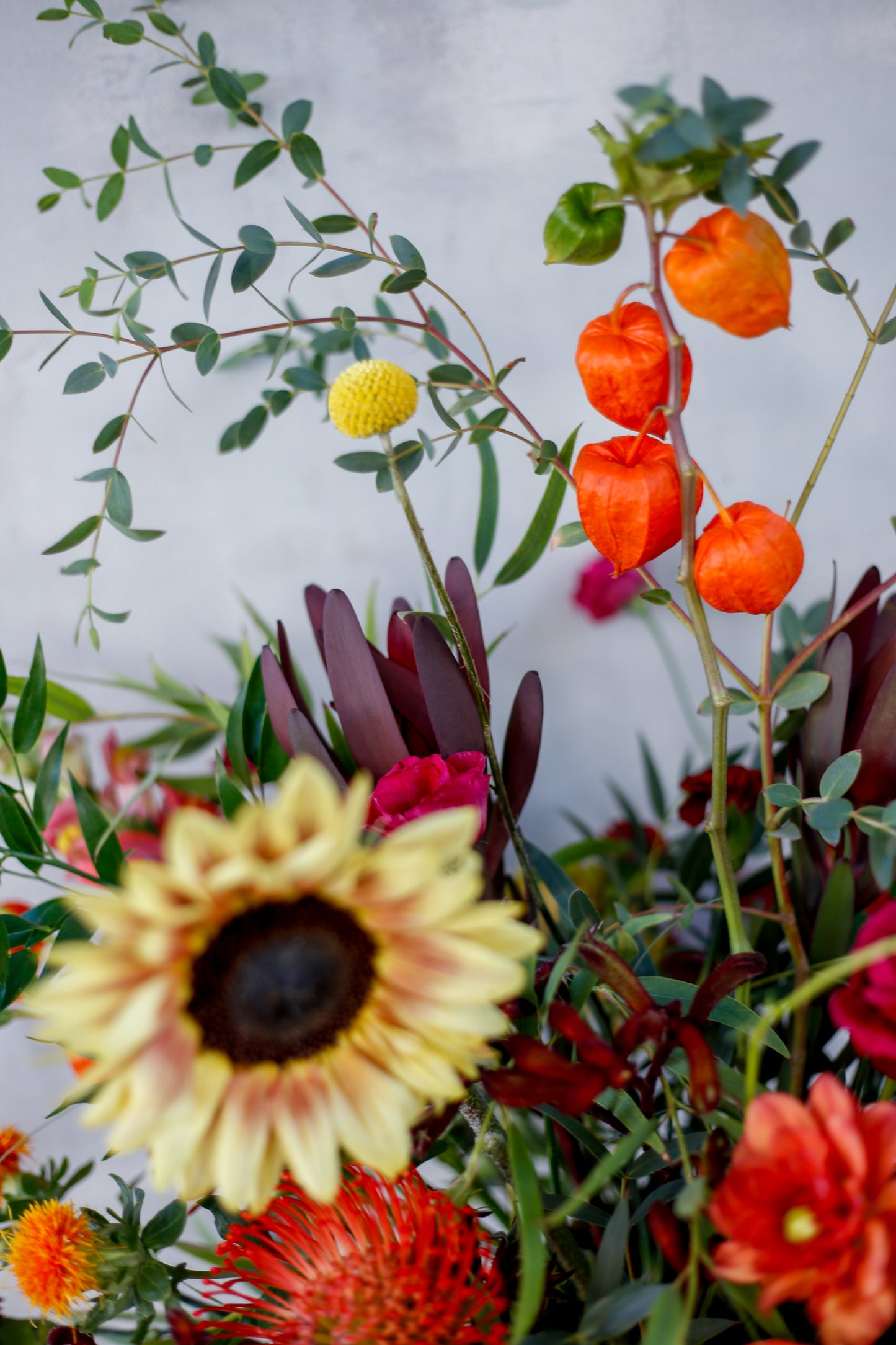 Arreglo de flores otoñal en copa burdeos