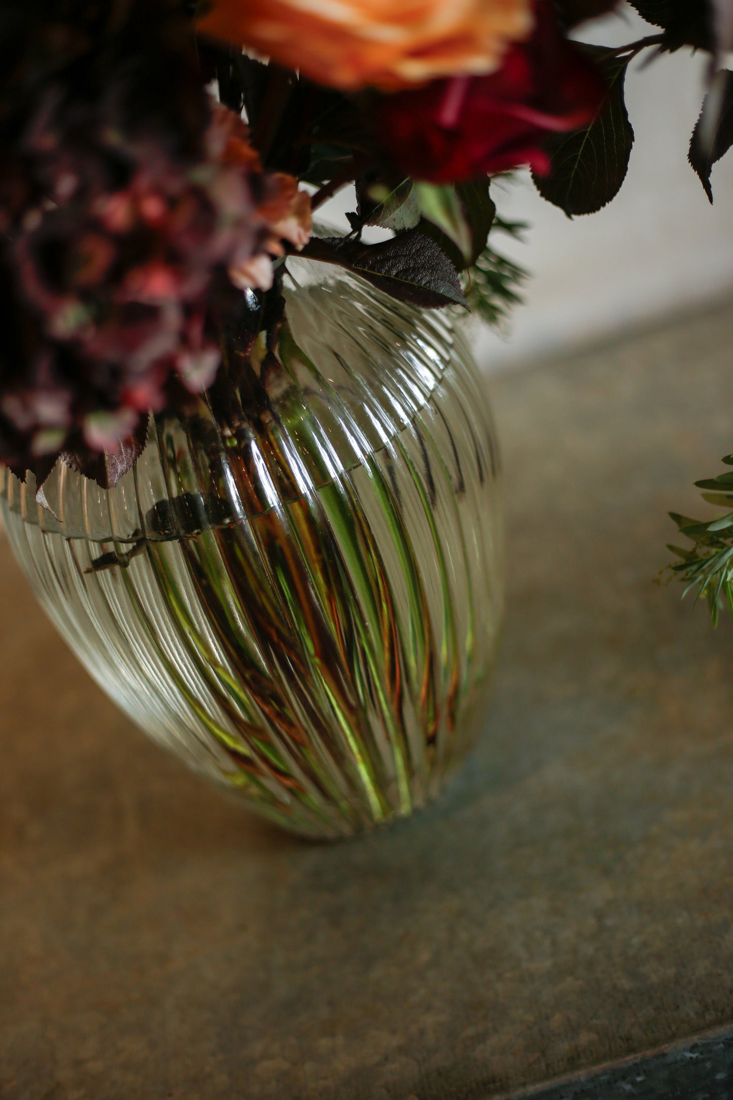Flores otoñales burdeos en jarrón acanalado